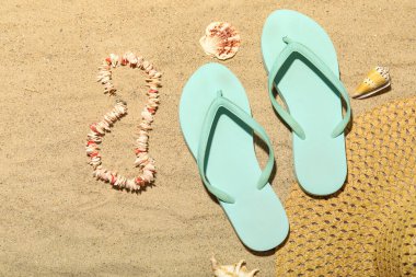 Kumda deniz kabuğu kolyeli terlikler.