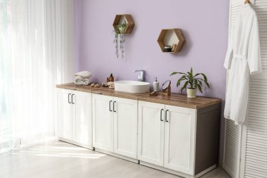 Katlanan ekran, banyo malzemesi ve lavabo olan çekmeceler. Banyonun içindeki leylak duvarın yanında.