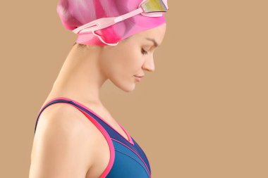 Bej arka planda profesyonel genç bayan yüzücü.