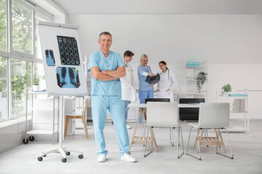 Klinikte X-ray görüntülerinin yanında yetişkin doktorlar var.