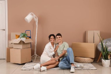 Genç çift taşınma gününde odada sarılıyor.