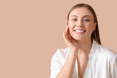 Bej arka planda sağlıklı cilde sahip güzel bir genç kadın. Yakın plan.