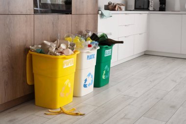 Mutfakta farklı türde çöp dolu çöp bidonları. Geri dönüşüm kavramı