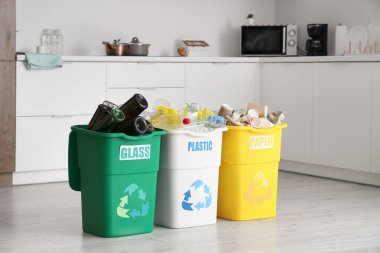 Mutfakta farklı türde çöp dolu çöp bidonları. Geri dönüşüm kavramı