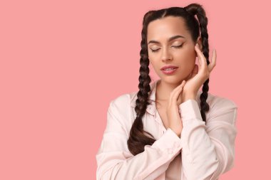 Pembe arka planda örgüleri olan güzel, genç ve şık bir kadın.