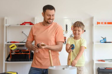 Mutlu baba ve farklı enstrümanlarla evde kahve masası kuran küçük oğlu.