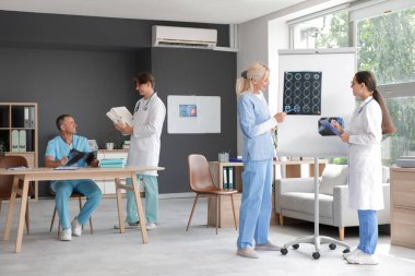 Kadın doktorlar klinikte x-ray resimleri üzerinde çalışıyor.