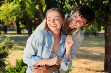 Güzel genç mutlu çift yaz parkında eğleniyor.