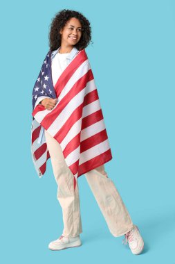 Mavi arka planda Amerikan bayrağı olan mutlu Afro-Amerikan kadın.