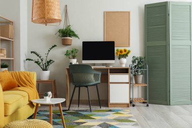 Çalışma odası ve bitkilerle dolu bir oturma odası.