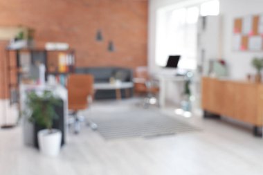 Masaları, raf üniteleri ve kanepesi olan modern ofisin bulanık görüntüsü