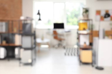 Çalışma yeri, raf üniteleri ve bitkilerle modern ofisin bulanık görünümü