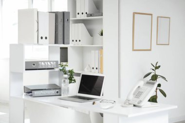 Çalışma yeri ve raf üniteleri olan hafif ofisin içi