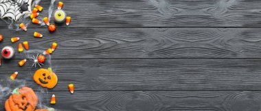 Lezzetli Cadılar Bayramı şekerli kompozisyon ve koyu ahşap zemin üzerinde kurabiyeler metin için alan