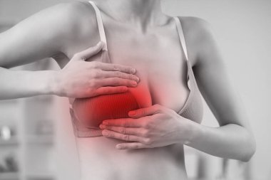 Genç bir kadın göğsünü kontrol ediyor, yakın plan. Kanser farkındalığı kavramı