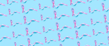 Mavi arka planda bir sürü pembe kurdele var. Göğüs kanseri farkındalığı için örnek 