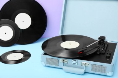 Leylak duvarının yanındaki masada vinil diskleri olan kayıt çalar