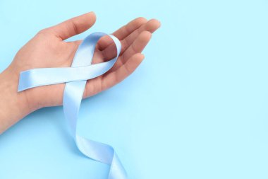 Mavi arka planda farkındalık kurdelesi olan kadın, yakın plan. Diyabet kavramı