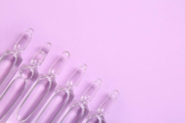 Leylak arka planında tıbbi ampuler, yakın plan.