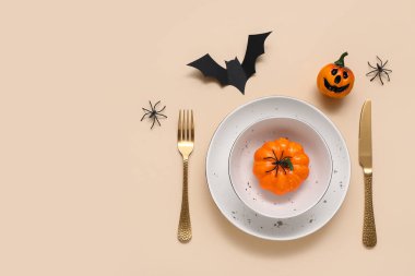 Cadılar Bayramı balkabakları ve bej arka planda yarasa ile şenlik masası