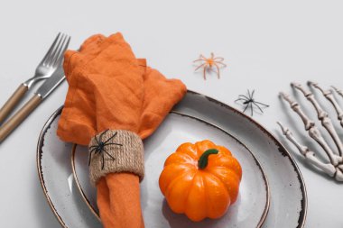 Cadılar Bayramı balkabağı ve gri arka planda örümceklerle şenlik masası.