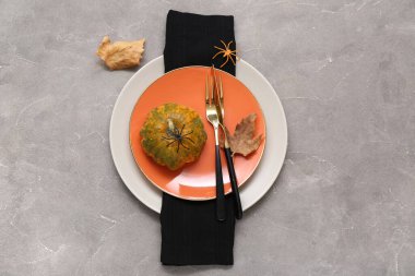 Cadılar Bayramı balkabağı ve gri grunge arka planda örümceklerle şenlik masası