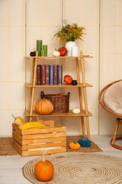 Oturma odasının içinde raf ünitesi ve Cadılar Bayramı balkabakları var.