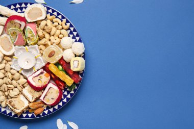 Yapraklar ve mavi arka planda farklı ikramlardan oluşan tabaklar. Divaly kutlaması