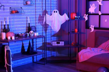 Cadılar Bayramı dekorlu ve raf üniteli karanlık oturma odasının içi.