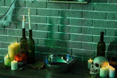 Balkabağıyla mum yakmak ve karanlık odada masanın üstünde Cadılar Bayramı dekoru