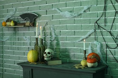 Balkabağıyla mum yakmak ve karanlık odada masanın üstünde Cadılar Bayramı dekoru