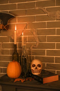 Cadılar Bayramı 'nda balkabağı, kafatası ve şömine rafında mum yakmak.