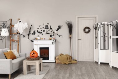 Cadılar Bayramı için kanepe ve şömineyle dekore edilmiş oturma odasının içi.