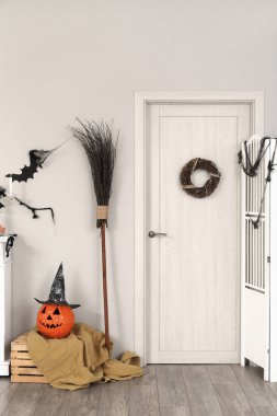 Cadılar Bayramı için kapı ve cadı süpürgesiyle dekore edilmiş oturma odasının içi.