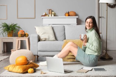 Evde çay içip ders çalışan genç bir kadın.