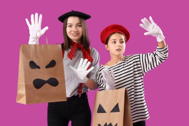 Annesiyle Cadılar Bayramı 'nda pandomimci gibi giyinen küçük bir kız.