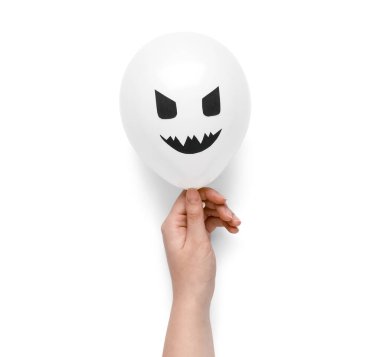 Beyaz arka planda komik bir Cadılar Bayramı balonu olan bir kadın eli.