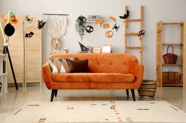 Cadılar Bayramı için kırmızı kanepeyle dekore edilmiş oturma odasının içi.