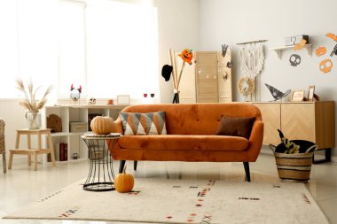 Cadılar Bayramı için kırmızı kanepe ve balkabaklarıyla dekore edilmiş oturma odasının içi.