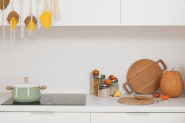 Mutfakta kavanozlar dolusu mutfak gereçleri ve Cadılar Bayramı balkabakları.