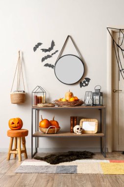 Şenlik salonunun içinde Cadılar Bayramı süslemeleri olan raf ünitesi.