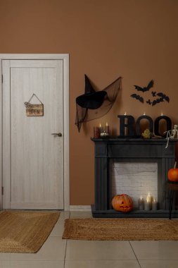 Şömineli, kapılı ve Cadılar Bayramı dekorasyonlu festival koridoru.