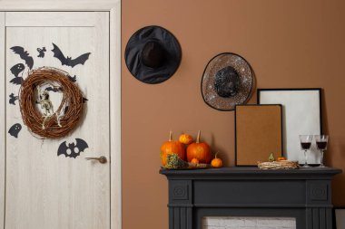 Cadılar Bayramı süslemeleri ve şenlik salonunda şarap kadehleri olan şömine rafı.