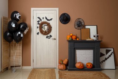 İçinde şömine, balon, kapı ve Cadılar Bayramı süslemeleri olan festival koridoru.