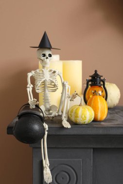 Cadılar Bayramı balkabaklı iskelet ve şömine rafında mumlar, yakın plan.