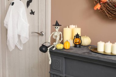 Cadılar Bayramı balkabaklı iskelet ve şömine rafında mumlar