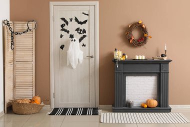 Cadılar Bayramı için salon kapısı ve şömine rafıyla süslenmiş.