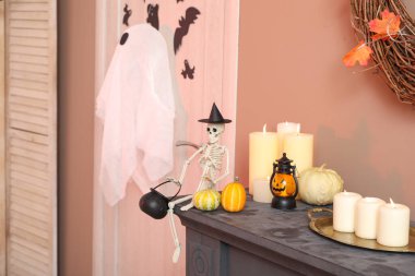 Cadılar Bayramı balkabaklı iskelet ve şömine rafında mumlar