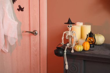 Cadılar Bayramı balkabaklı iskelet ve şömine rafında mumlar