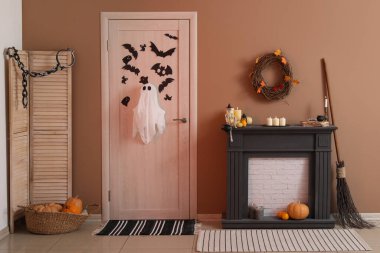 Cadılar Bayramı için salon kapısı ve şömine rafıyla süslenmiş.